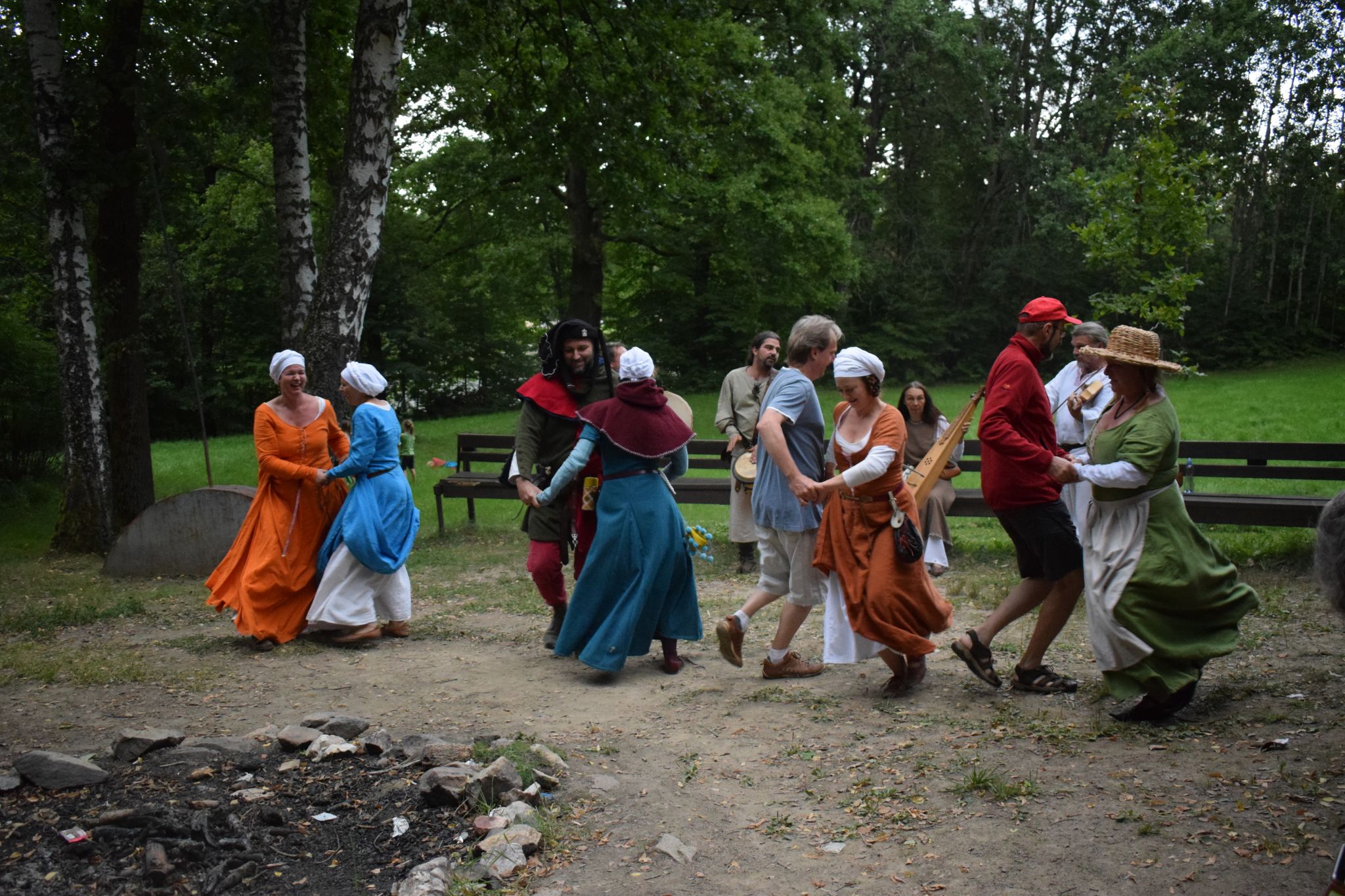 Návštěvníci a tanečnice tančí středověký tanec. 