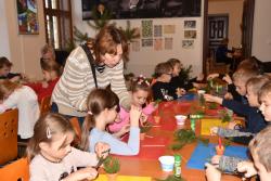 Děti si vyrábí během edukačního programu malý vánoční svícen z přírodních materiálů.