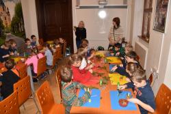 Děti si vyrábí během edukačního programu malý vánoční svícen z přírodních materiálů.